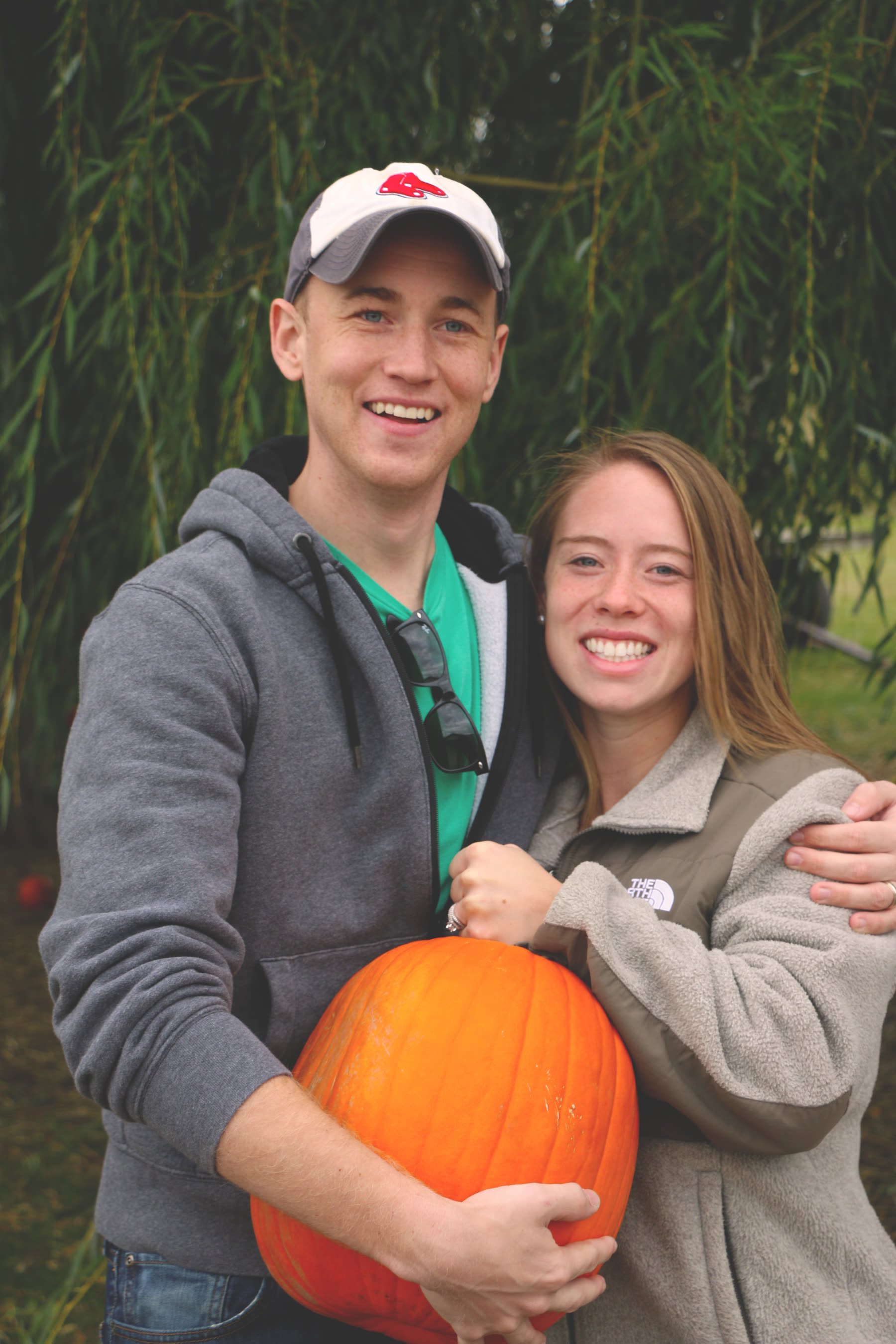 Two visitors holding a pumpkin